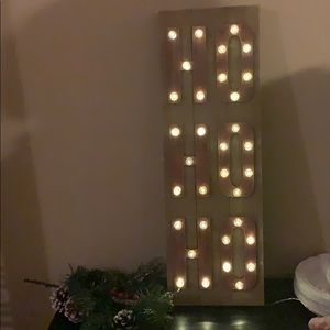 Ho ho ho sign that lights up on wood can be hung